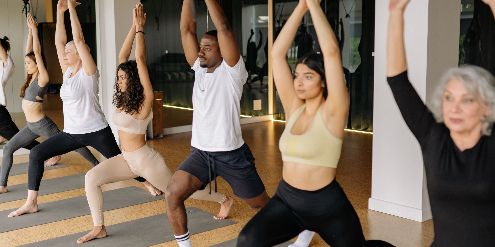 Row of performing yoga poses in a class