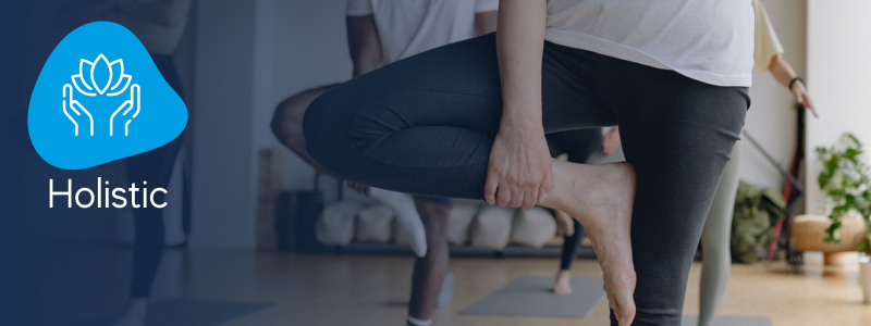 group of people stood on one leg with the other bent outwards with a icon indicating it is a fitness yoga holistic class