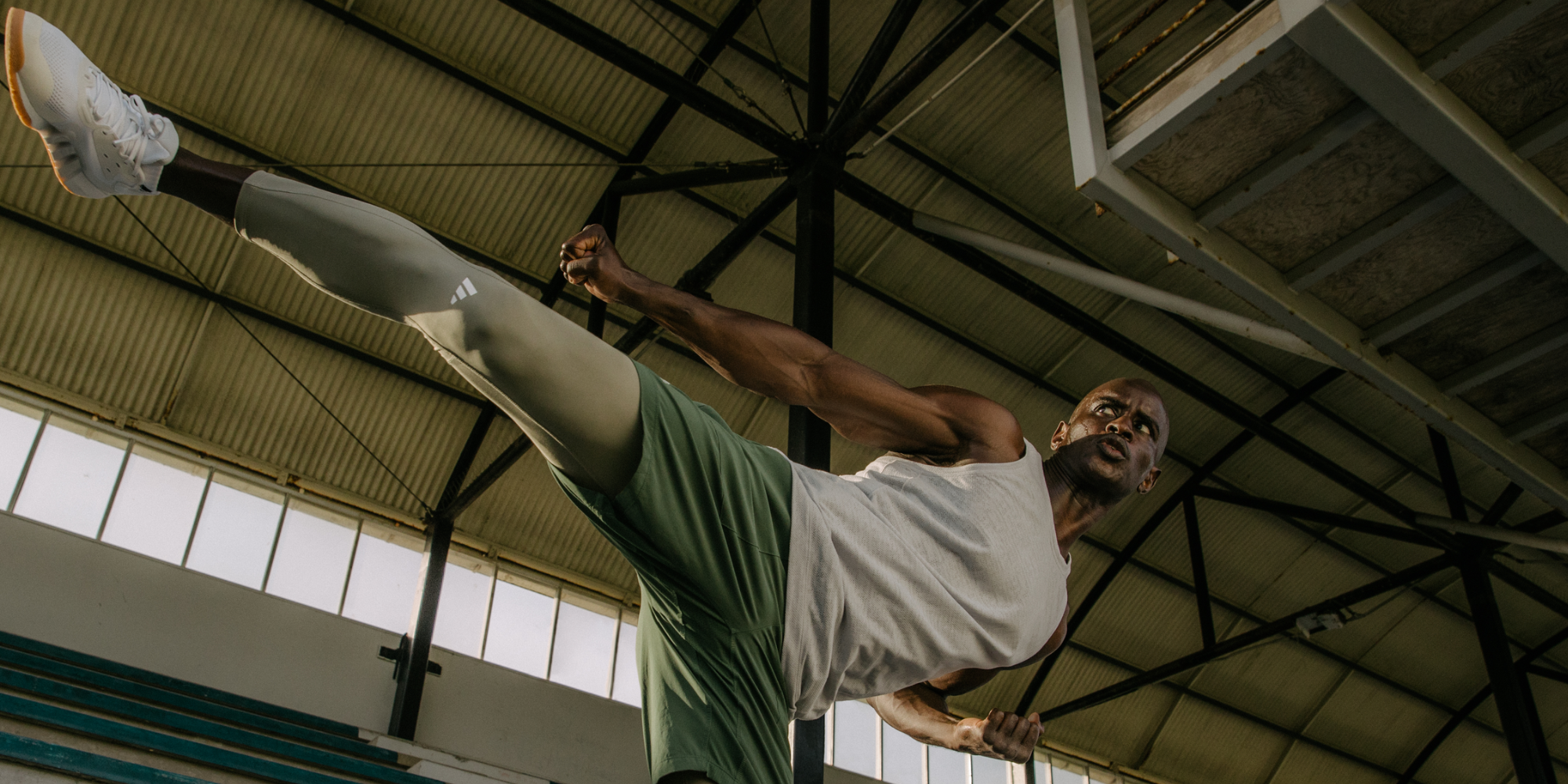 man performing an exercise by standing on one leg kicking out to the side