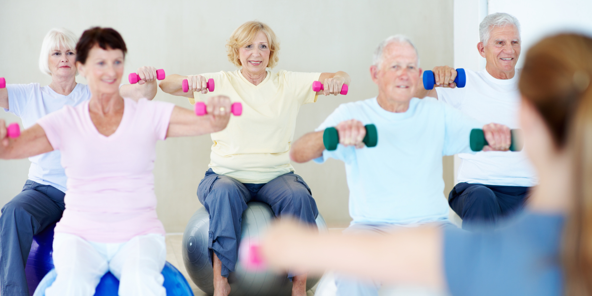 Group of older people holding dumbbells in an exercise class
