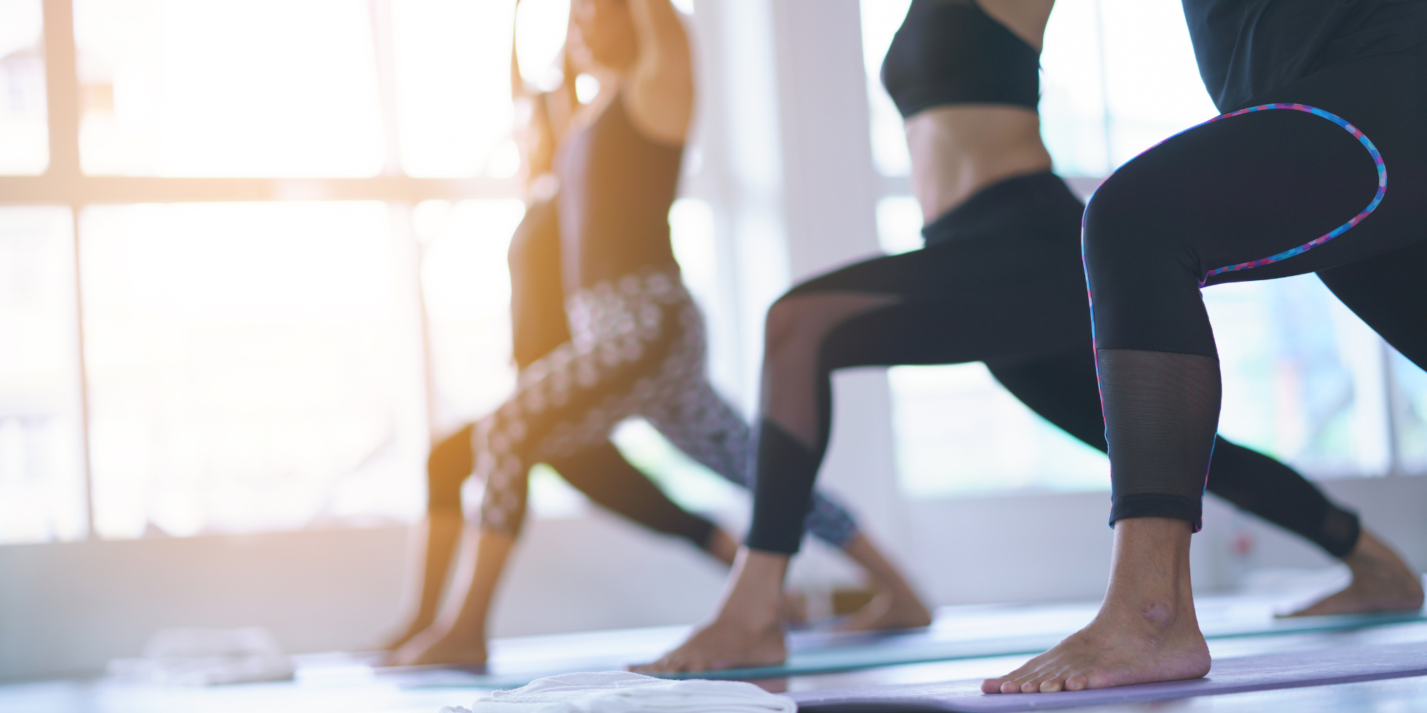 row of people in a lunge pose on exercise mats