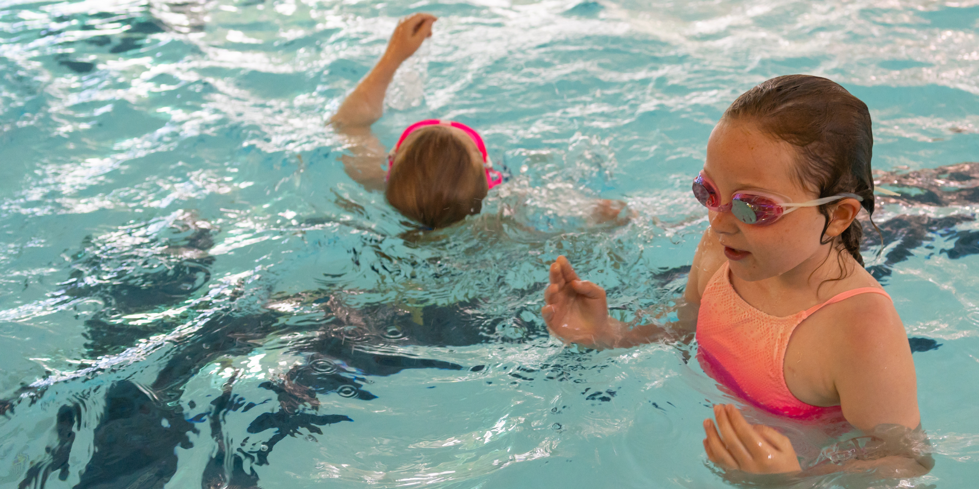 two girls playing in the swimming pool in a holiday swim