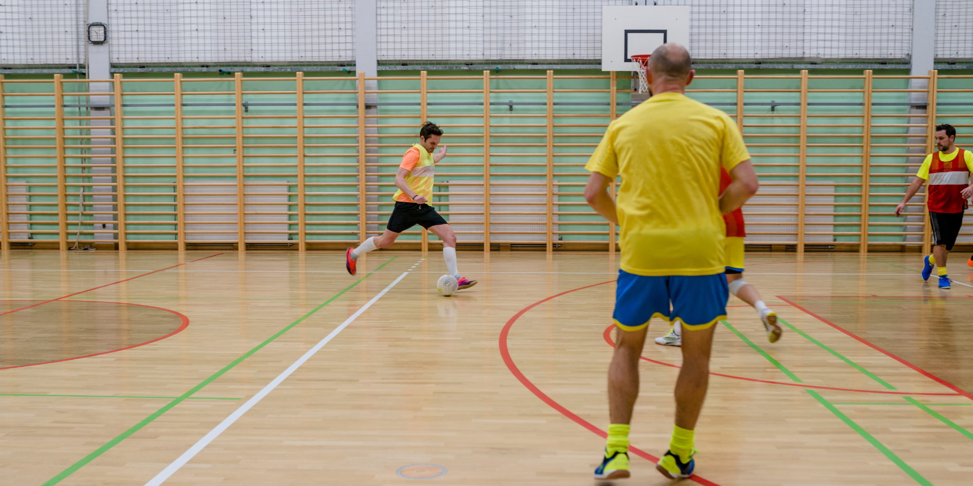 two teams playing football in a sports hall