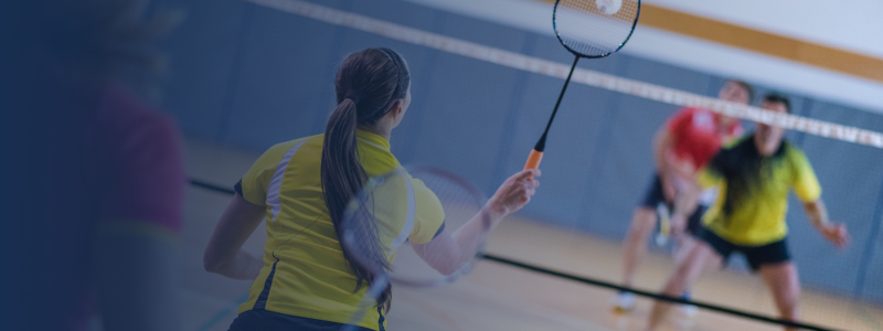 four people playing a game of mixed doubles badminton