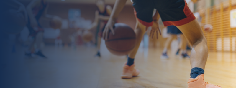 person bouncing a basketball during a game with other players in the background