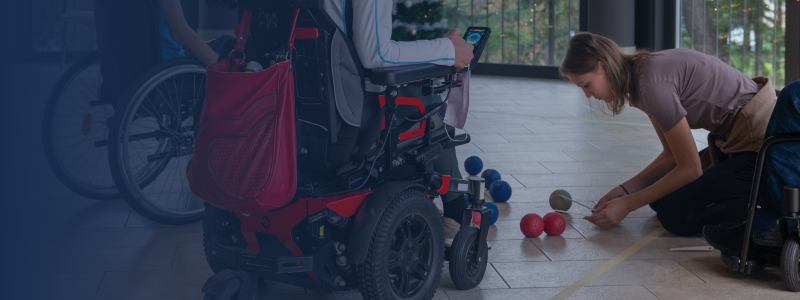 person measuring the distance between ball in a boccia game whilst the players watch from their wheelchairs
