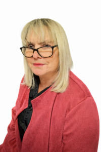Bev looking at the camera with glasses and red top